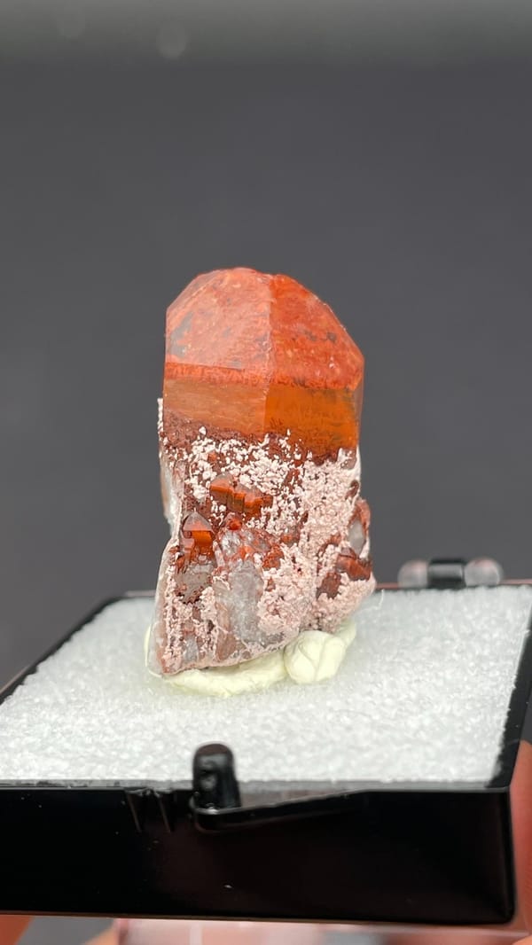 Deep red hematoid quartz crystal with frosted base from Shanxi, China, in a box, detail of the matrix contact
