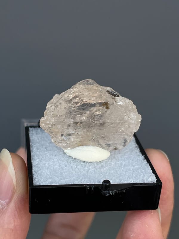 Pale straw topaz crystal in white matrix from Yunnan, China, in a display box, close-up of the crystal faces