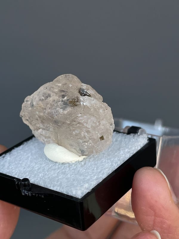 Pale straw topaz crystal in white matrix from Yunnan, China, in a display box, reverse side