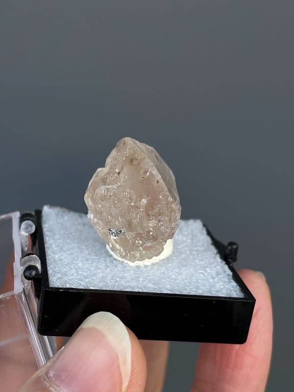 Pale straw topaz crystal in white matrix from Yunnan, China, in a display box, top view
