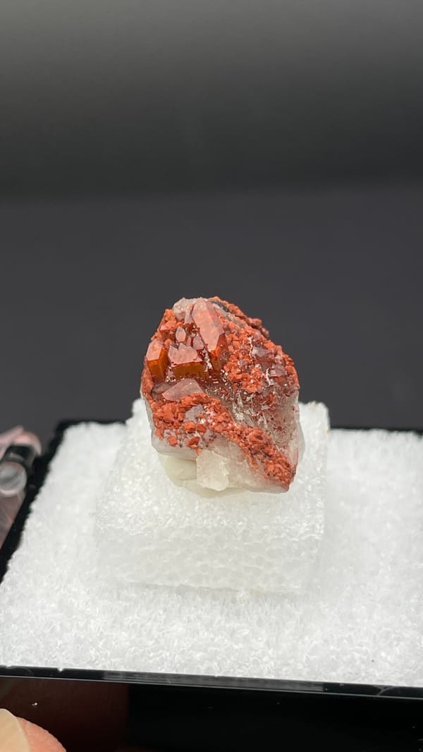 Small deep red hematoid quartz crystal group from Shanxi, China, in a display box