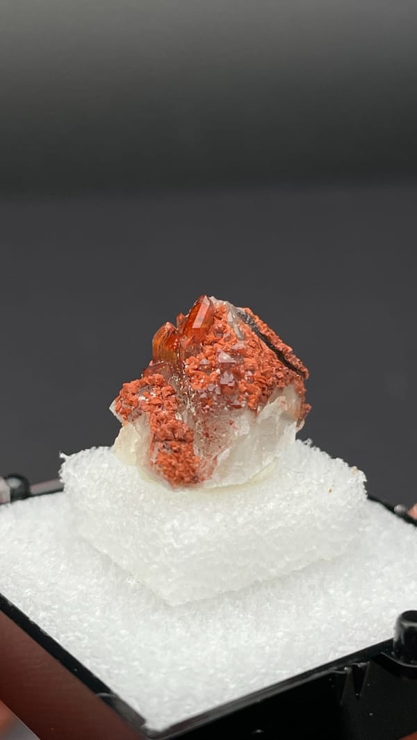 Small deep red hematoid quartz crystal group from Shanxi, China, in a display box, second angle