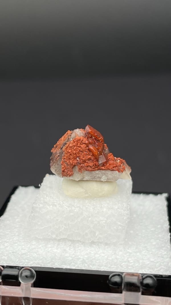 Small deep red hematoid quartz crystal group from Shanxi, China, in a display box, top view