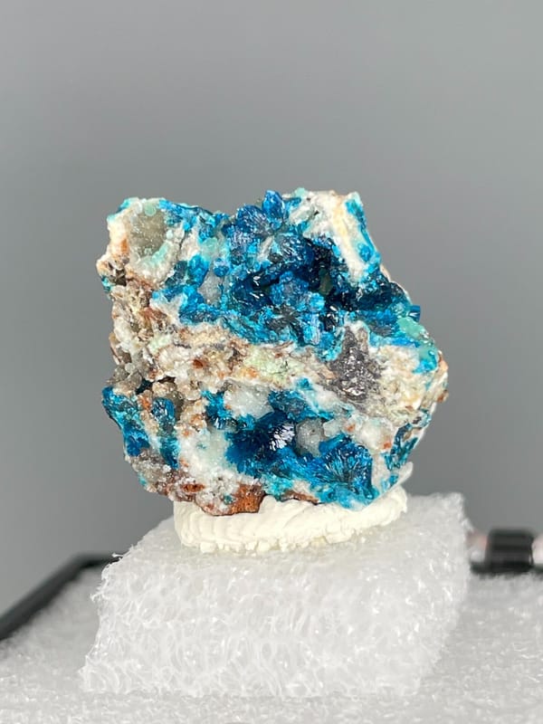 Strong blue veszelyite patches across a pale rock from Yunnan, China, close-up of the crystal faces