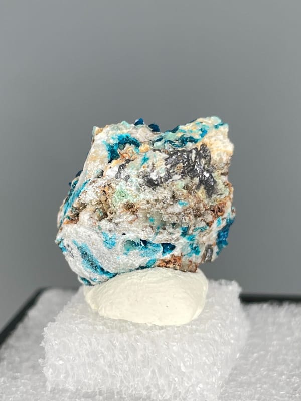 Strong blue veszelyite patches across a pale rock from Yunnan, China, detail of the matrix contact