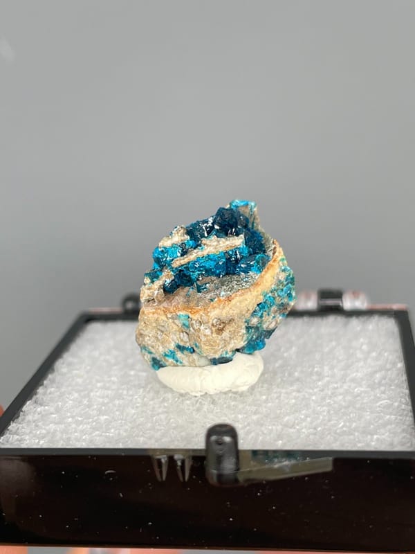Blue veszelyite divided by a tan rock seam from Yunnan, China, in a box
