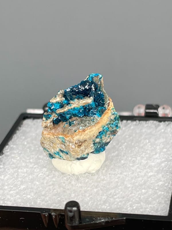 Blue veszelyite divided by a tan rock seam from Yunnan, China, in a box, second angle