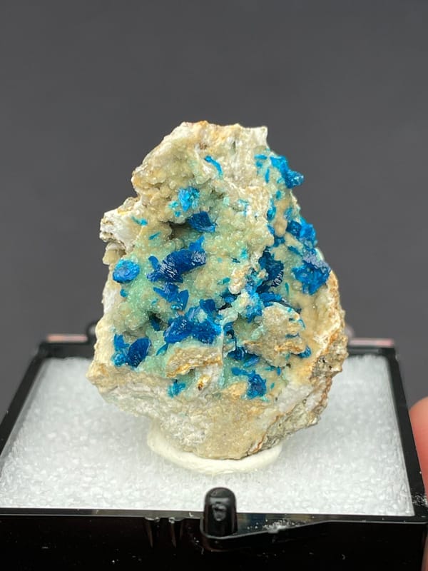 Blue veszelyite clusters scattered on a pale green matrix from Yunnan, China