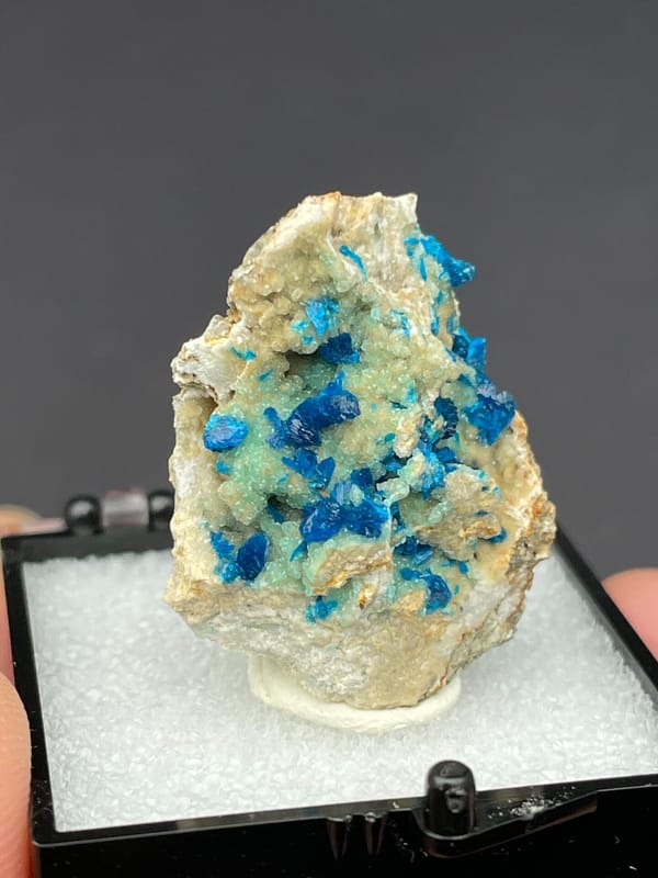 Blue veszelyite clusters scattered on a pale green matrix from Yunnan, China, second angle