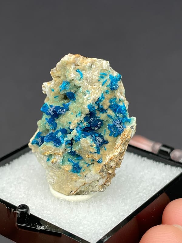 Blue veszelyite clusters scattered on a pale green matrix from Yunnan, China, reverse side