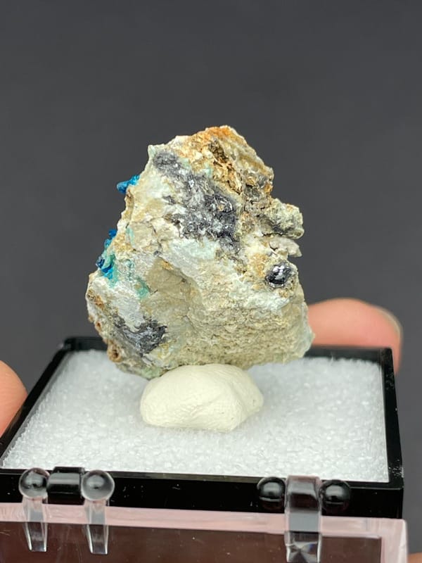 Blue veszelyite clusters scattered on a pale green matrix from Yunnan, China, detail of the matrix contact