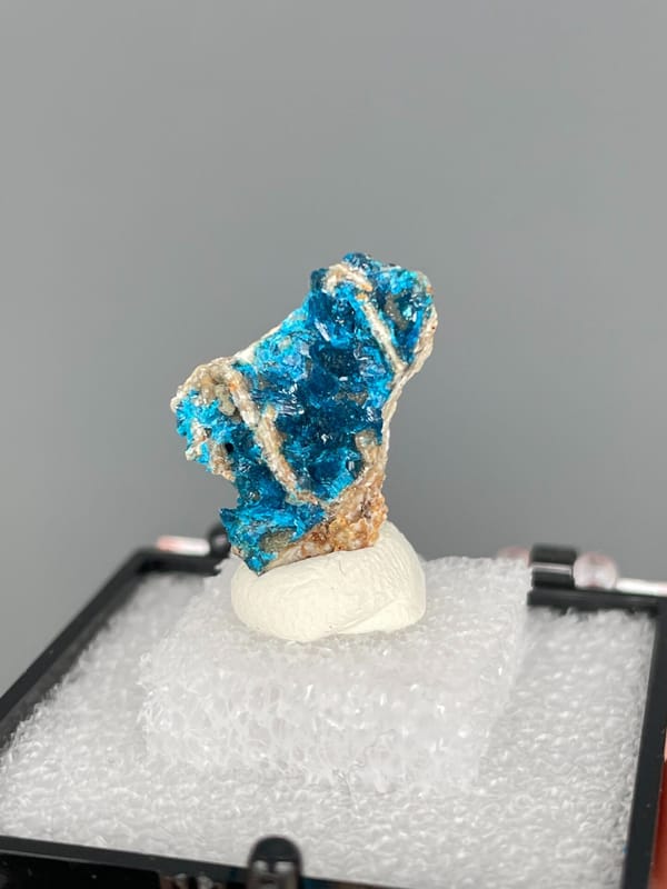 Blue veszelyite crust crossed by a pale vein, Yunnan, China, in a display box, reverse side