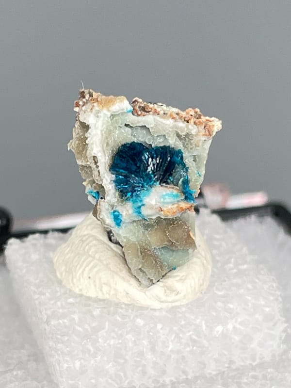Small deep blue veszelyite crust on pale rock from Yunnan, China, in a box, reverse side