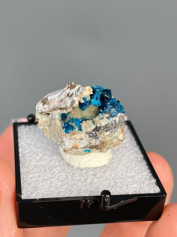 Deep blue veszelyite in the hollows of a pale cream rock, Yunnan, China, detail of the matrix contact