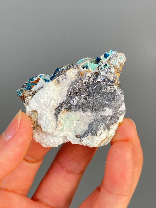 Deep blue veszelyite with turquoise patches on grey rock from Yunnan, China, top view