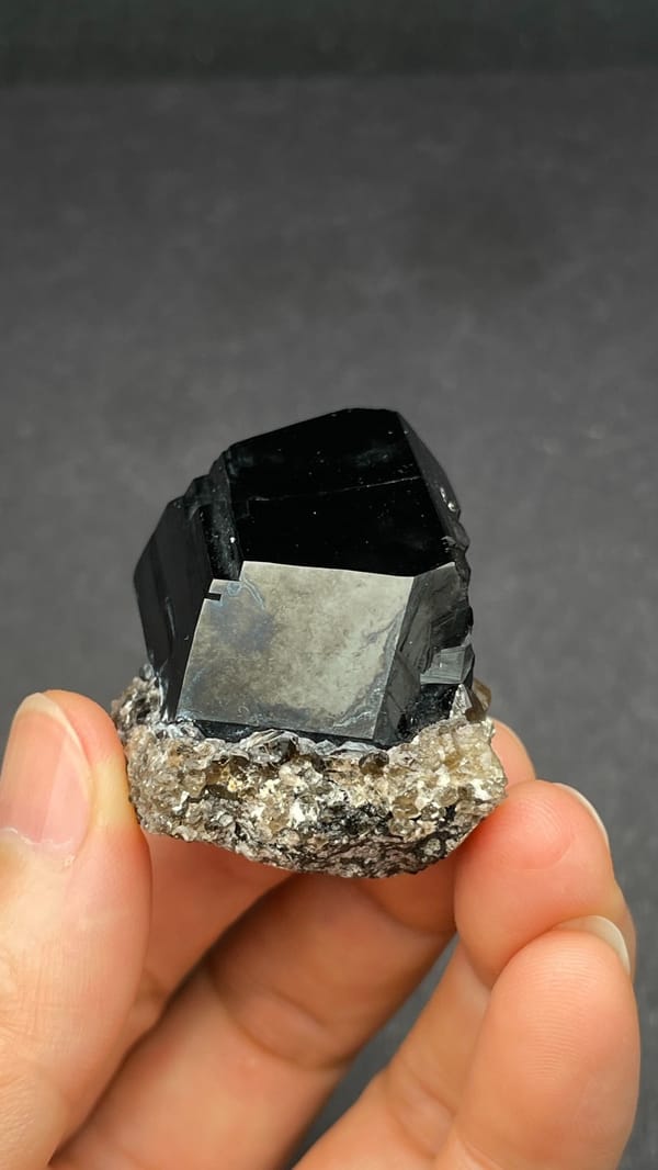 Black schorl tourmaline with three-faced termination on matrix, Namibia, close-up of the crystal faces
