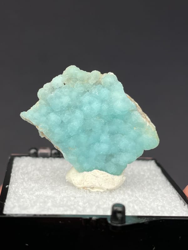 Pale turquoise botryoidal hemimorphite crust from Yunnan, China, in a display box, second angle