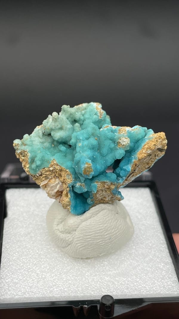 Turquoise botryoidal hemimorphite on tan matrix from Yunnan, China, in a box