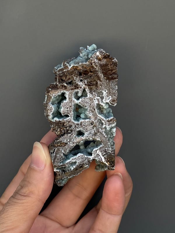 Pale blue-green hemimorphite lining an open skeletal rock, Yunnan, China, close-up of the crystal faces