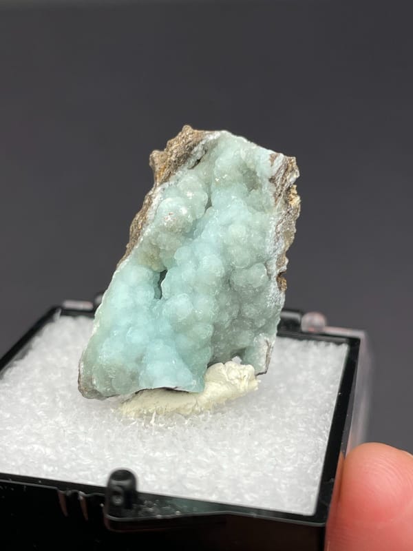 Pale mint hemimorphite crust on brown rock from Yunnan, China, in a box, reverse side