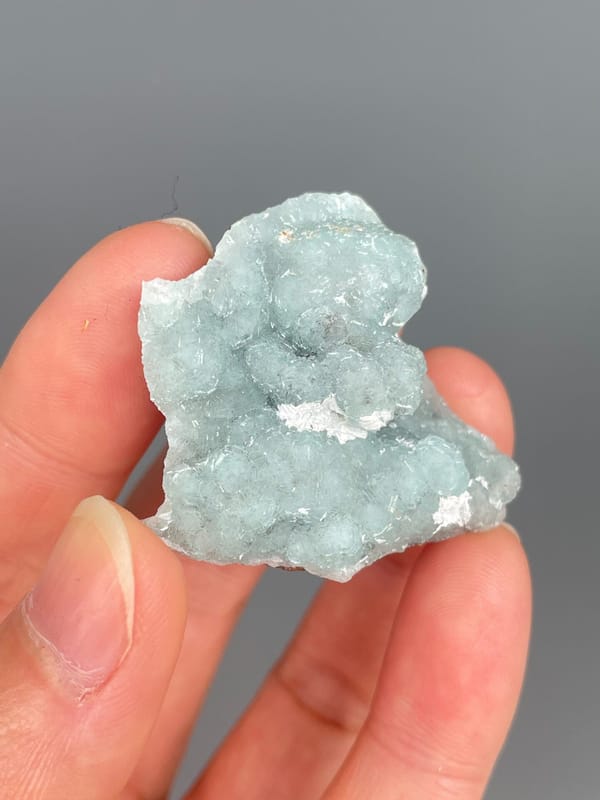 Pale mint-green botryoidal hemimorphite crust from Yunnan, China, held in hand
