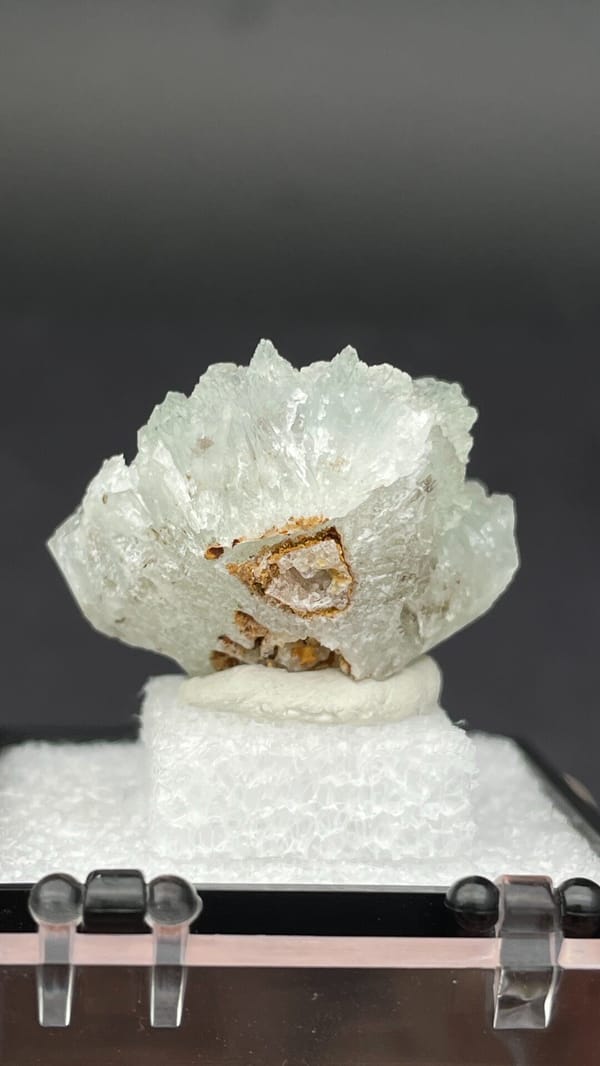 Pale mint-white bladed hemimorphite crust from Yunnan, China, in a display box, detail of the matrix contact
