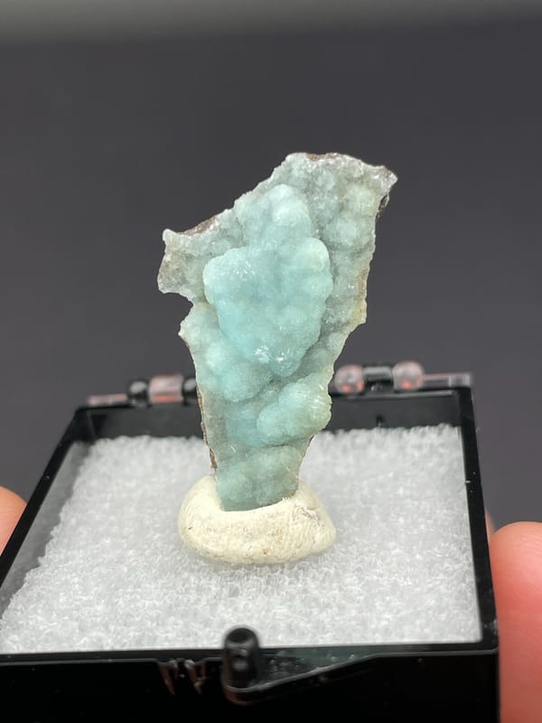 Pale blue-green botryoidal hemimorphite crust from Yunnan, China, in a display box