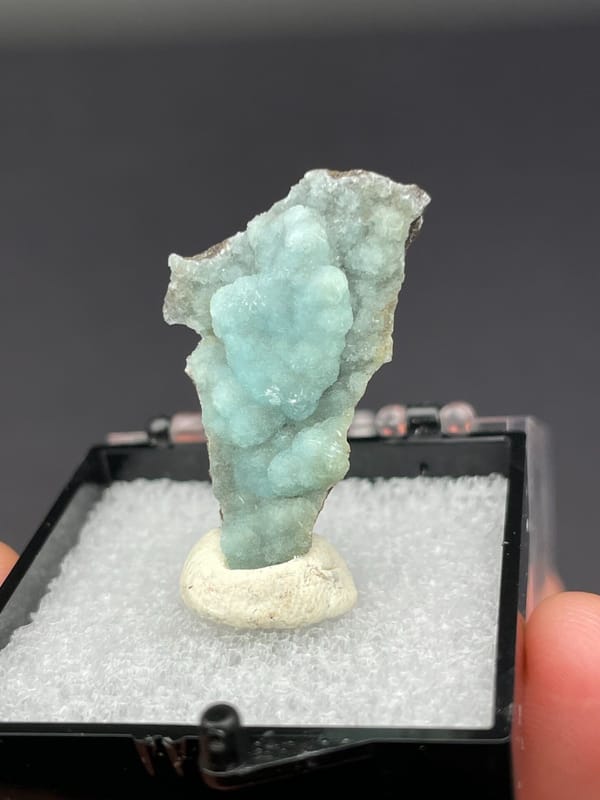 Pale blue-green botryoidal hemimorphite crust from Yunnan, China, in a display box, second angle