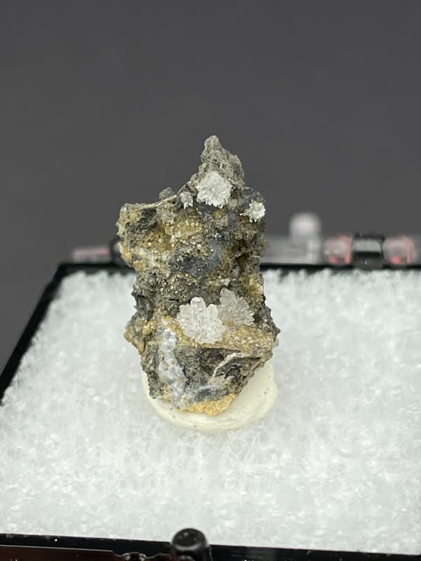 Colourless hemimorphite flower rosette on dark matrix from Guangxi, China