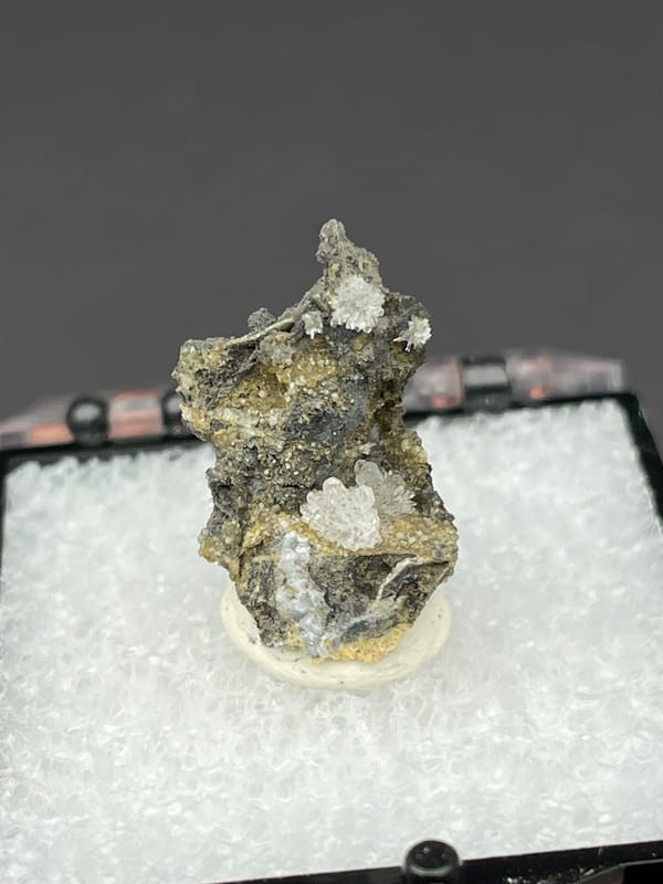 Colourless hemimorphite flower rosette on dark matrix from Guangxi, China, second angle