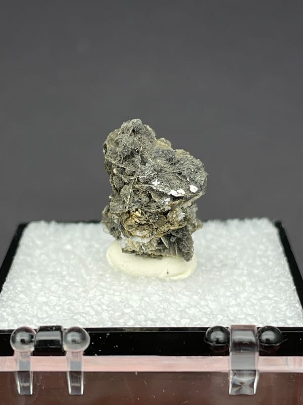 Colourless hemimorphite flower rosette on dark matrix from Guangxi, China, detail of the matrix contact