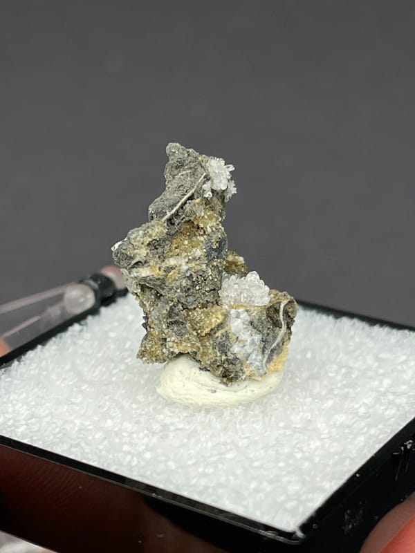 Colourless hemimorphite flower rosette on dark matrix from Guangxi, China, close-up of terminations