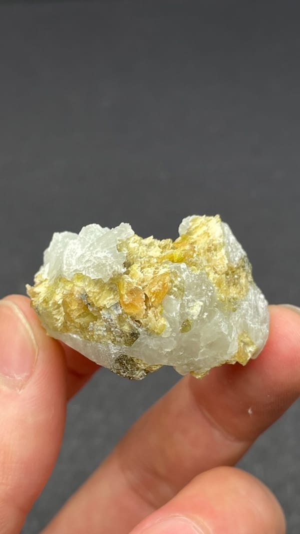 White botryoidal prehnite with yellow-green clinozoisite blades from Peru, detail of the matrix contact