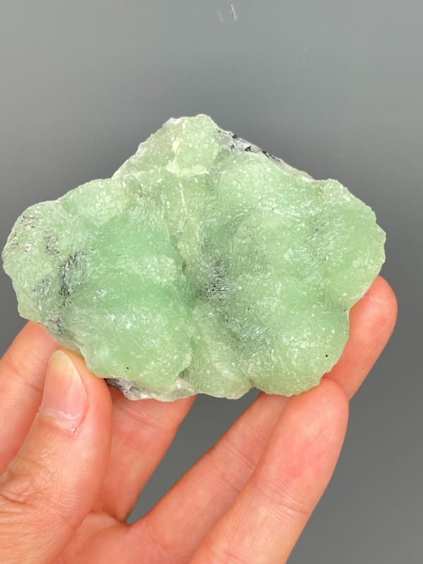 Apple-green botryoidal prehnite plate from Sichuan, China, detail of the matrix contact