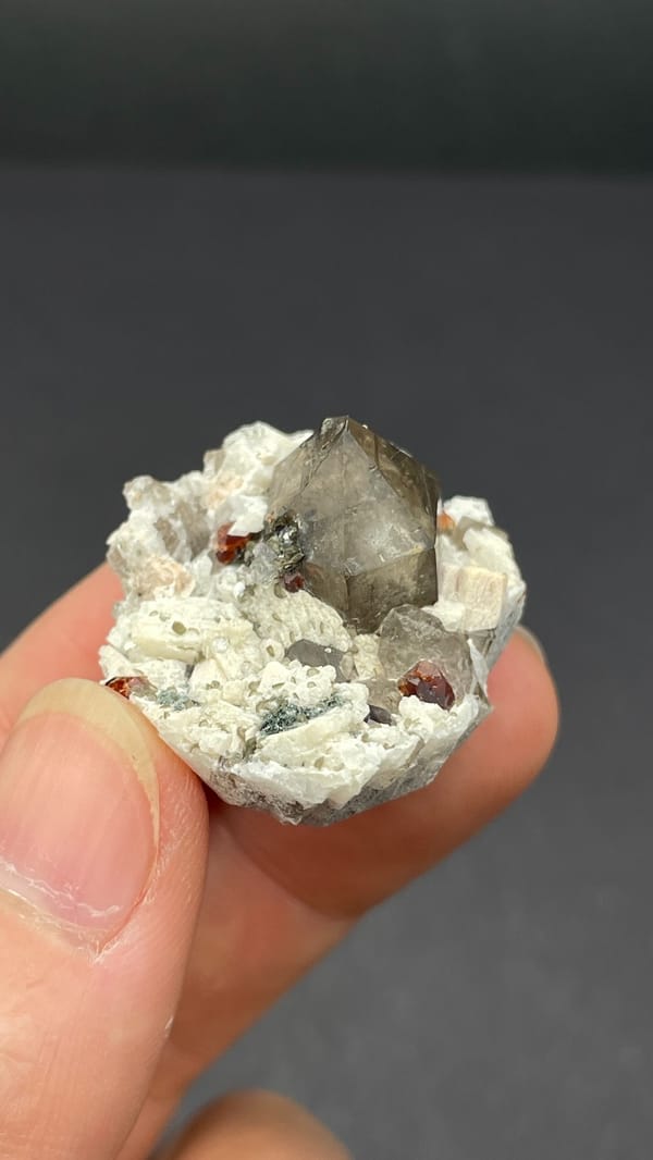 Smoky quartz and red garnets in white feldspar from Yunxiao, Fujian, China, second angle
