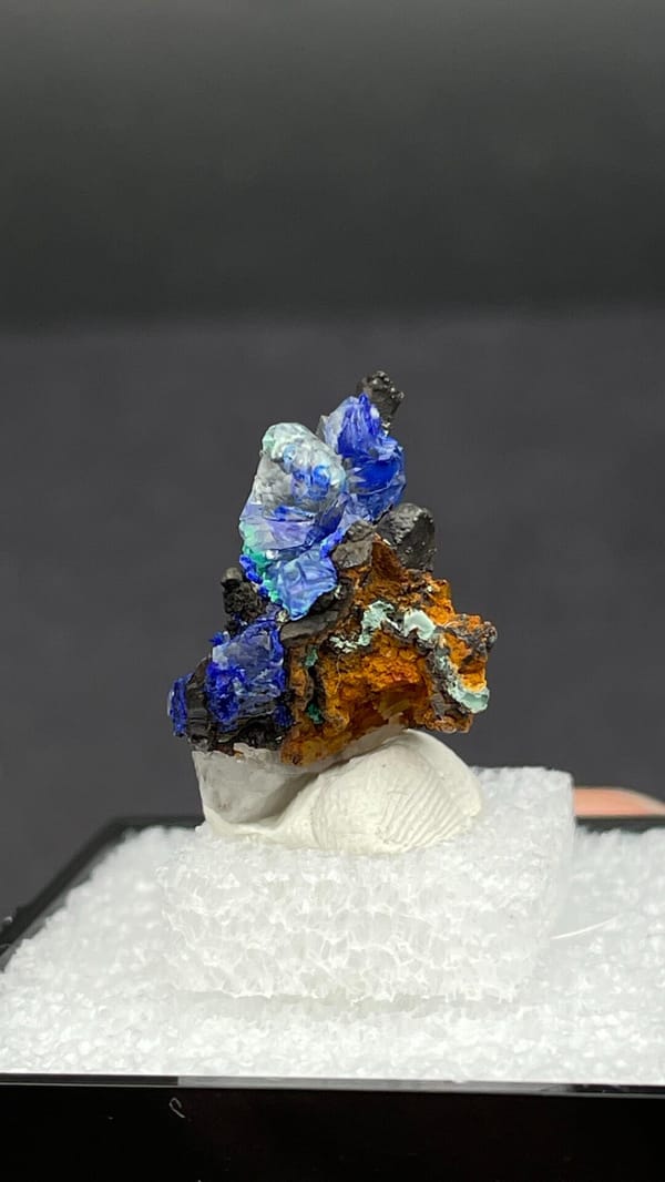 Electric blue azurite with green malachite on limonite from Morocco, in a box, close-up of the crystal faces