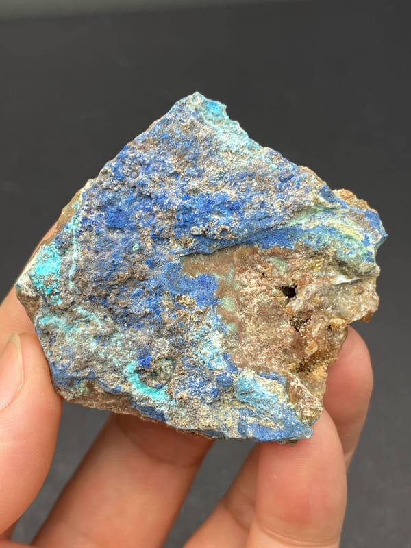 Deep blue azurite crust spread across a rock slab from Yunnan, China, close-up of the crystal faces