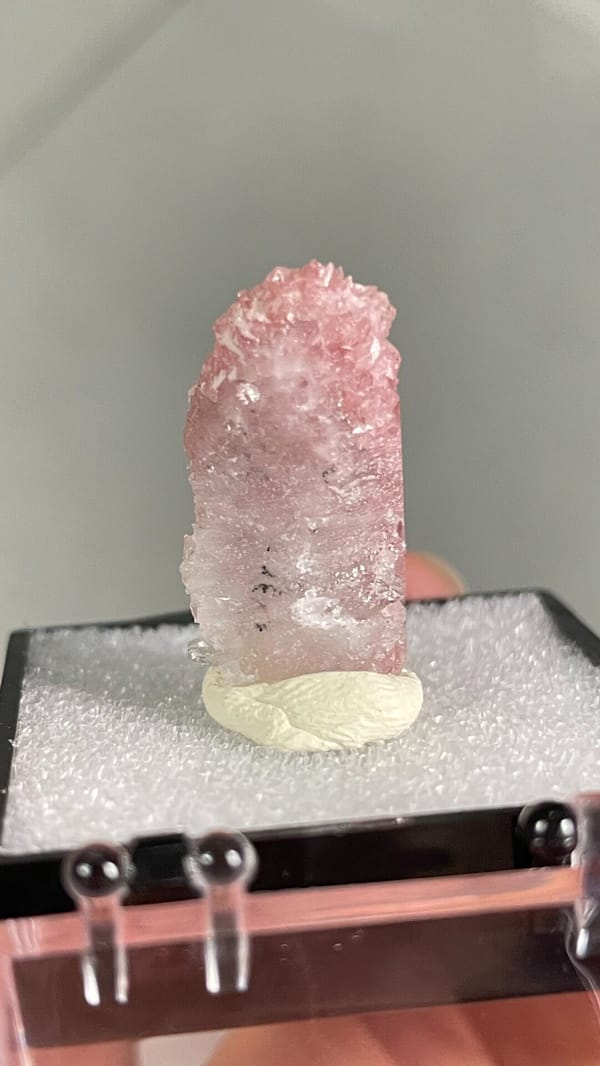 Rose-pink rhodochrosite crust from Wuzhou, Guangxi, China, in a display box, reverse side