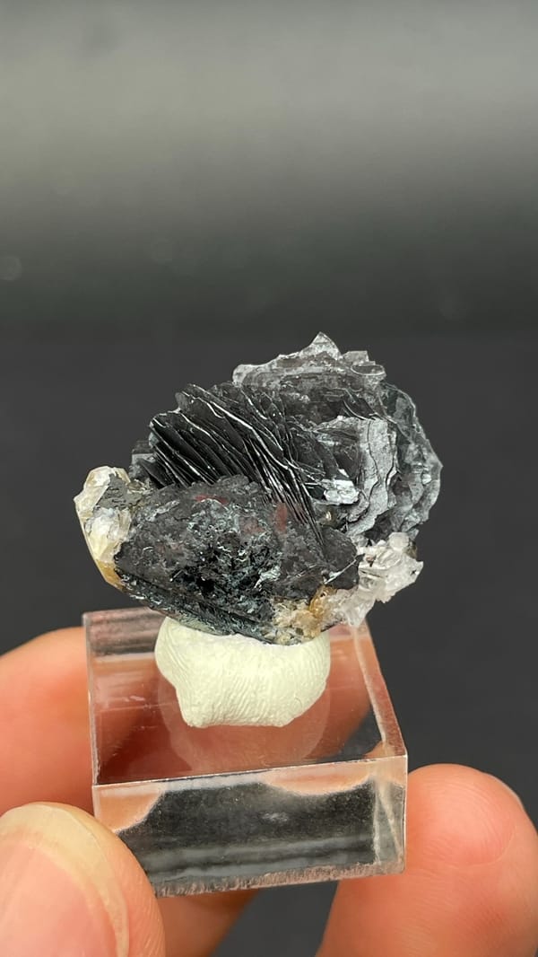 Dark metallic specular hematite flower from Jinlong, Guangdong, China, on a stand