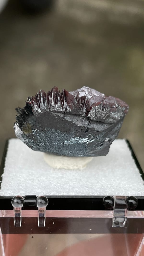 Dark metallic specular hematite rosette with clear quartz, Jinlong, Guangdong, detail of the matrix contact