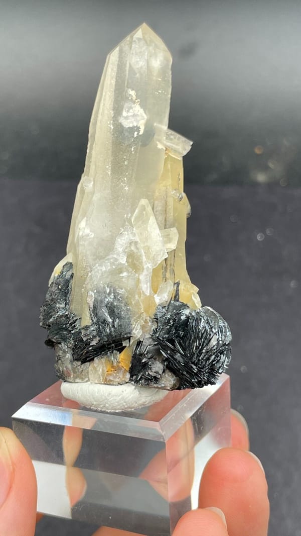 Pale quartz spire rising from black specular hematite, Guangdong, China, second angle