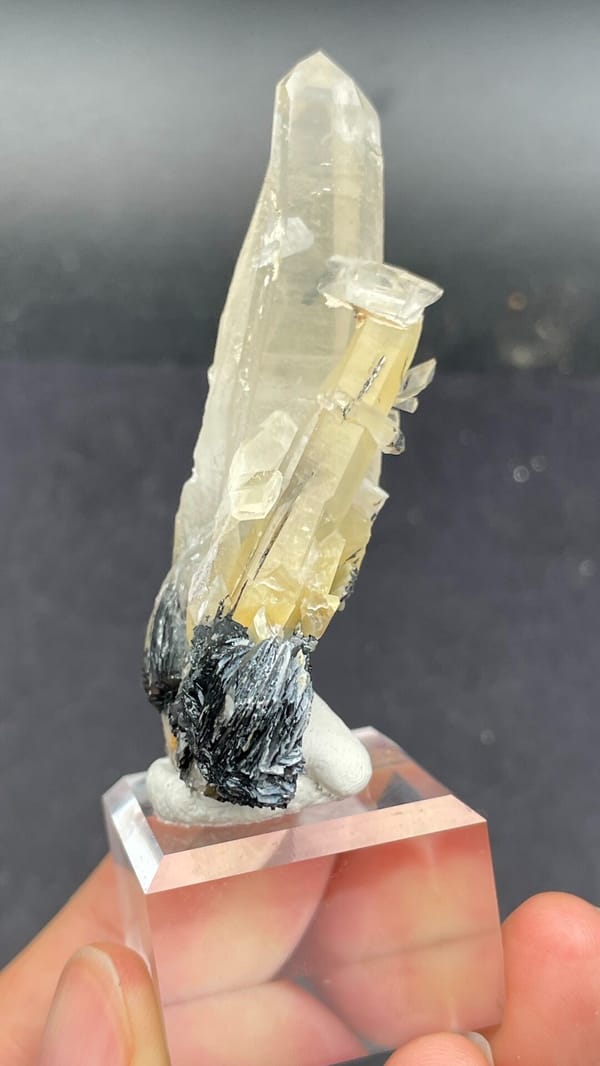 Pale quartz spire rising from black specular hematite, Guangdong, China, close-up of the crystal faces