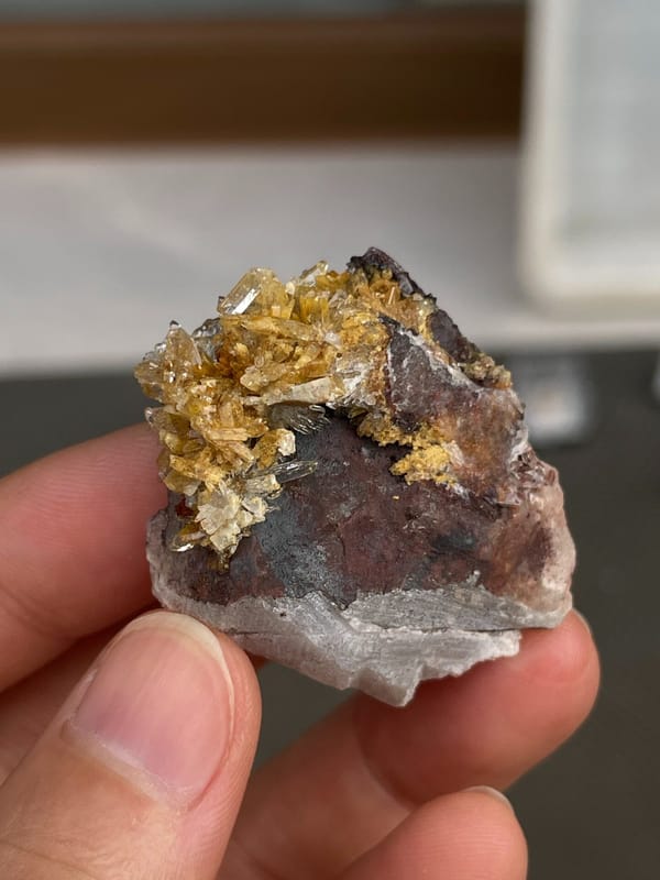 Amber-gold creedite crystals on brown matrix from Guizhou, China, reverse side