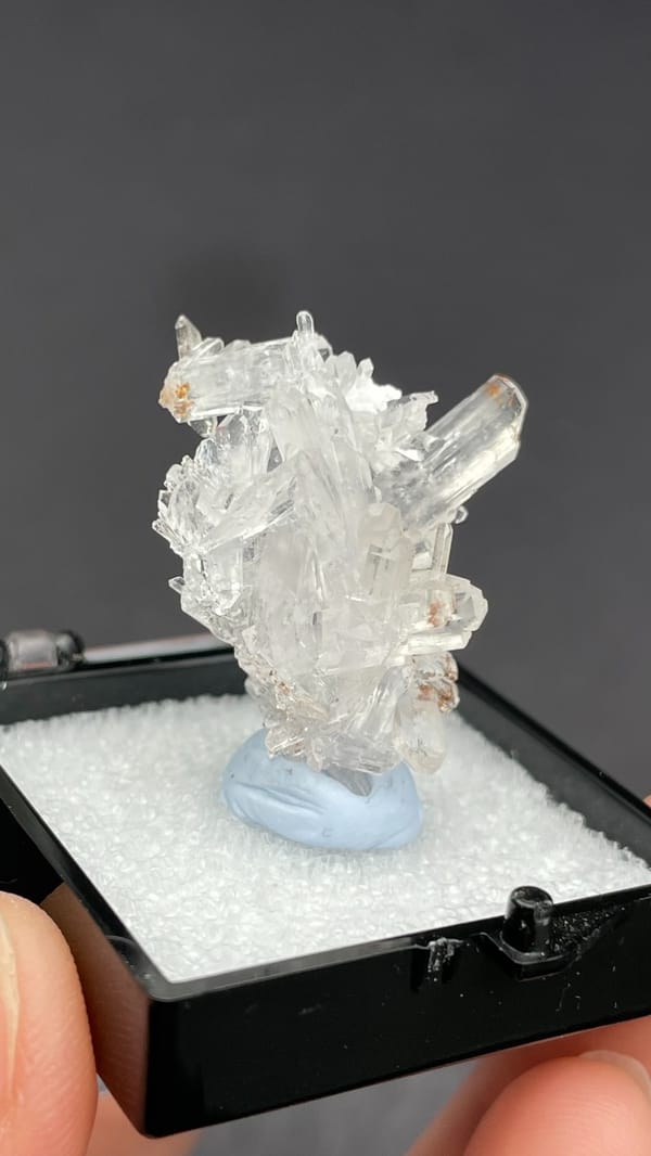 Colourless glassy creedite crystal spray from Guizhou, China, in a display box, second angle