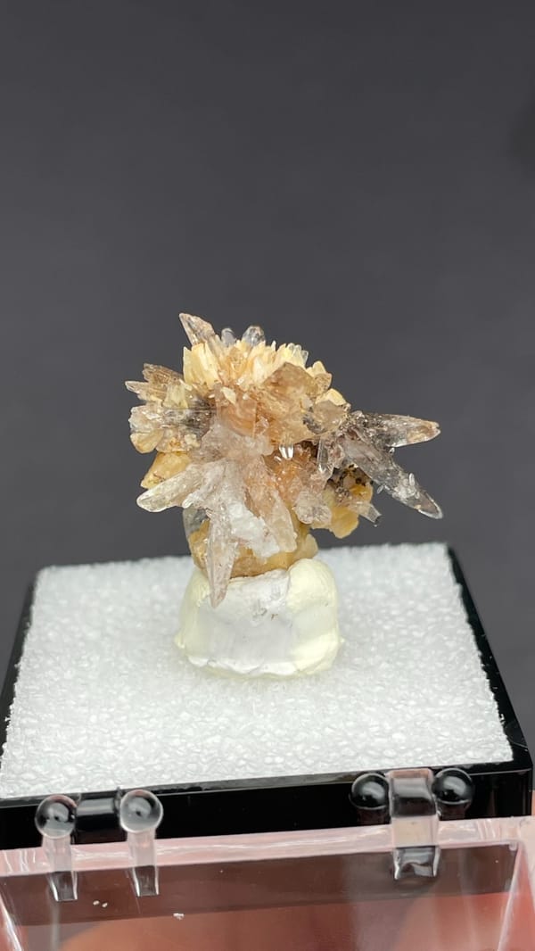 Colourless creedite and gypsum crystals radiating around a rock core, Guizhou, China, close-up of the crystal faces