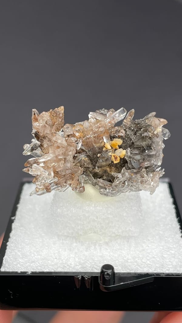 Colourless creedite spray around a small yellow stone from Guizhou, China, second angle