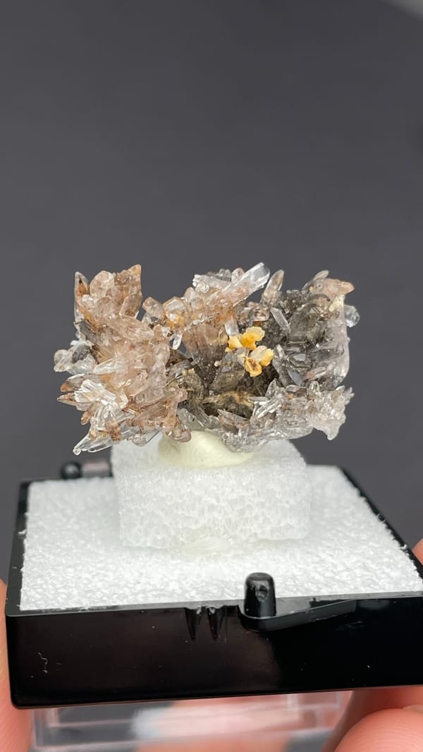 Colourless creedite spray around a small yellow stone from Guizhou, China, reverse side