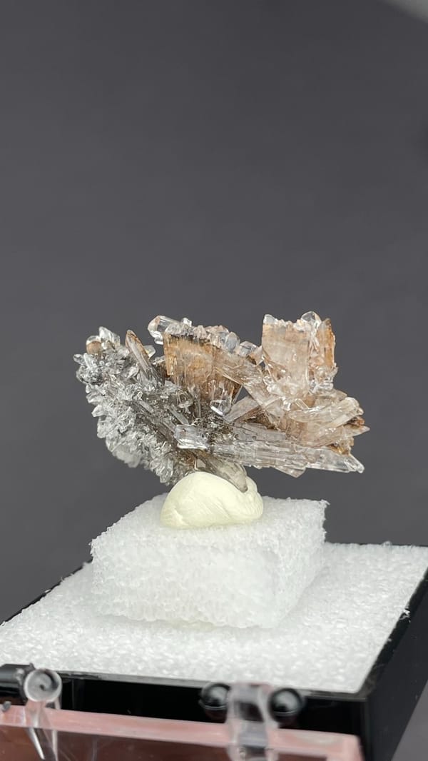 Colourless creedite spray around a small yellow stone from Guizhou, China, top view