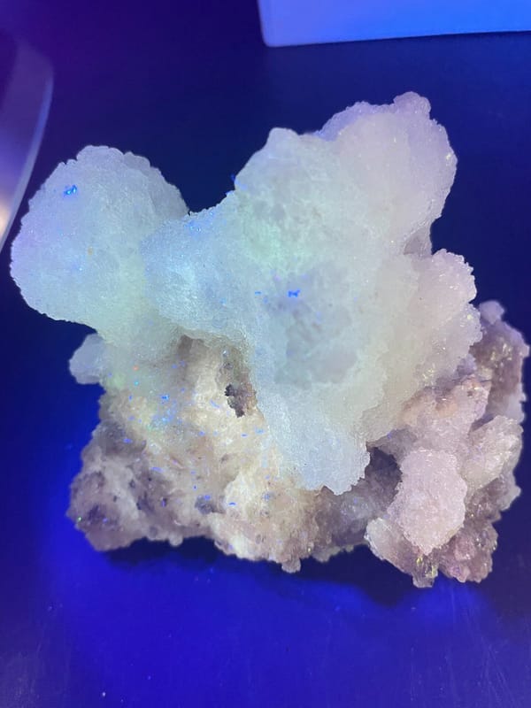 Large white creedite crystal crust on pale base from Guizhou, China, side view
