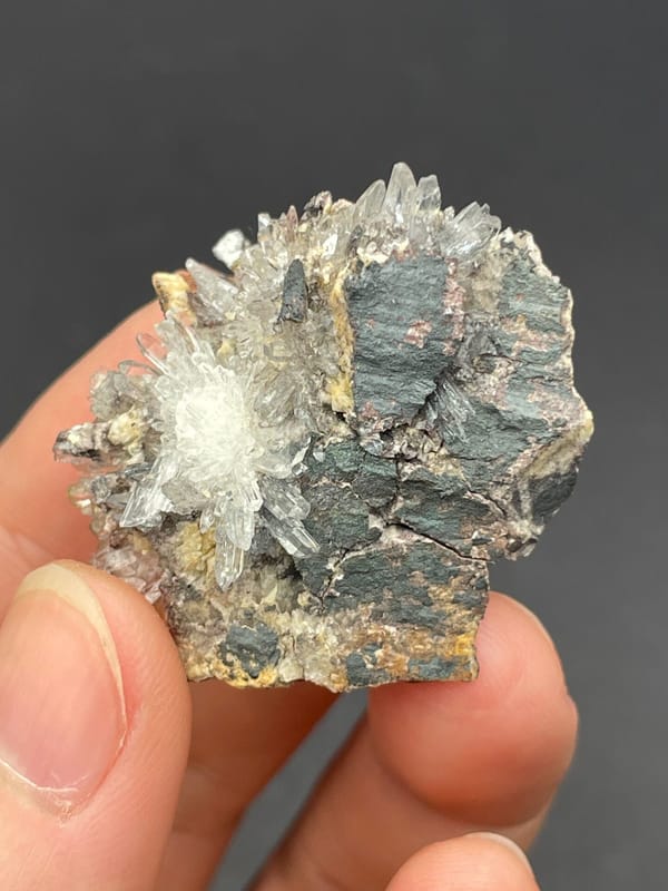 White creedite needle sprays on a grey-brown rock from Guizhou, China